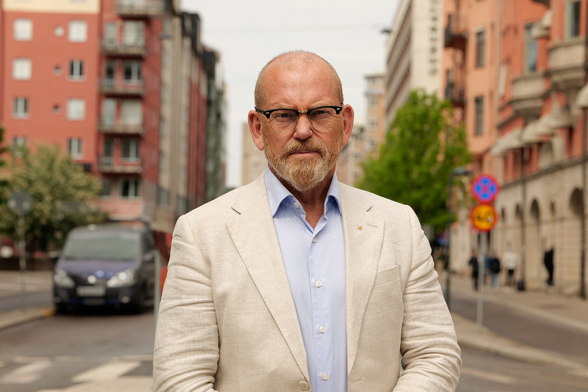 Skallig man med skägg och ljus kostym på en innerstadsgata i Stockholm