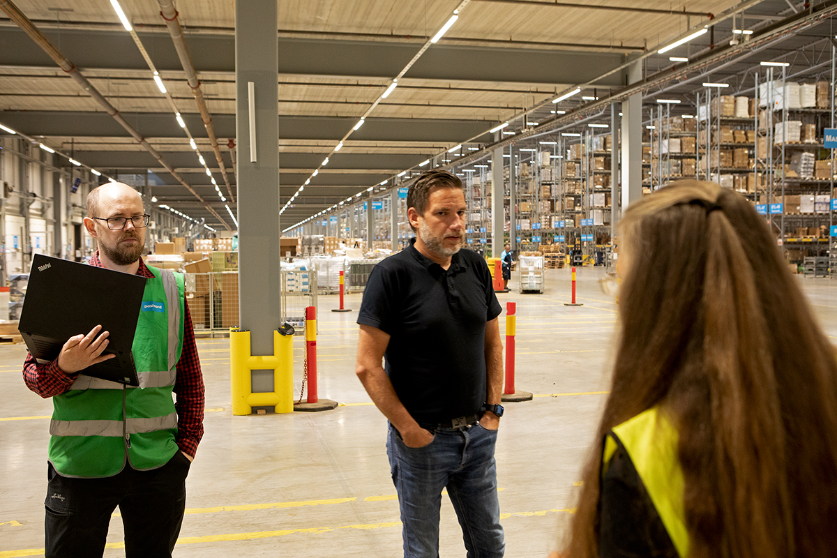 Ute på stora golvet. Logistikutvecklaren Johannes Algotsson och Christian Johansson, produktionschefen diskuterar med Transports ombudsman Nina Broman Costa från Linköpingsavdelningen. Foto: John Antonsson