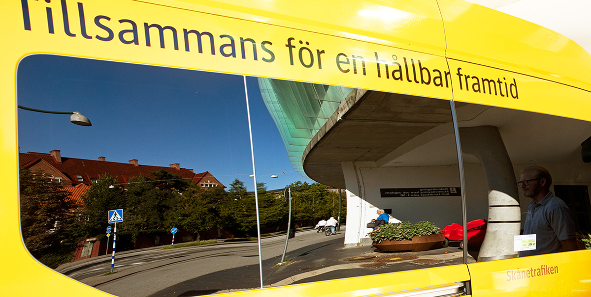 Spegling i sidorutor på gul färdtjänstbuss